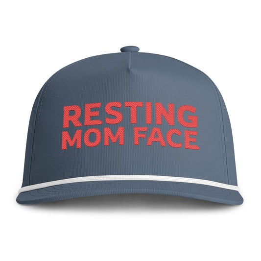Image of an indigo hat with red embroidery reading "Resting Mom Face"