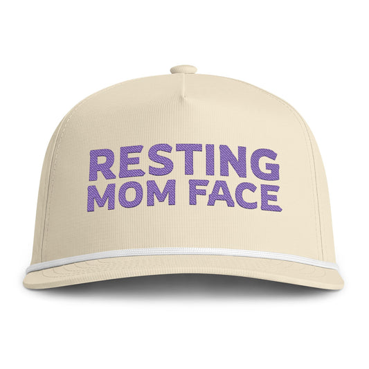 Image of an ivory hat with purple embroidery reading "Resting Mom Face"