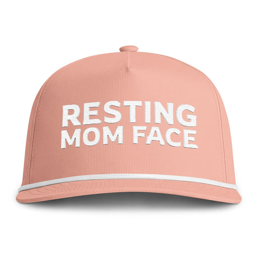 Image of a peach hat with white embroidery reading "Resting Mom Face"
